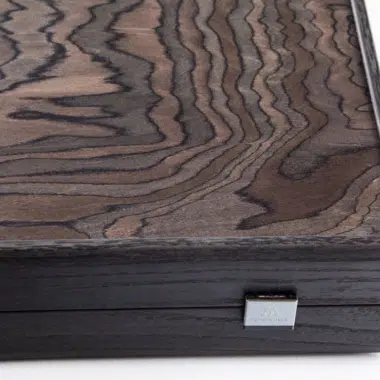Détail du coin du coffret fermé montrant le fermoir métallique et le grain du bois