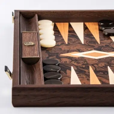 Coin du backgammon en racine de noyer avec pions blancs et noirs rangés