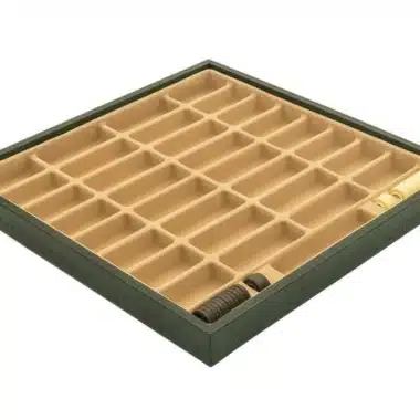 Coffret de rangement en similicuir vert ouvert, compartiments vides avec quelques pièces visibles