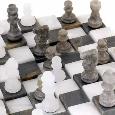 Détail des pièces d'échecs en marbre antique disposées en diagonale sur l'échiquier