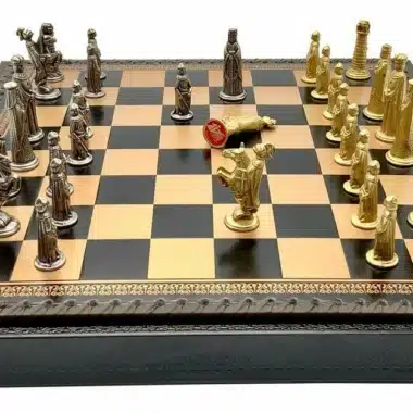 Pièces d'échecs médiévales en métal massif disposées en milieu de partie sur l'échiquier