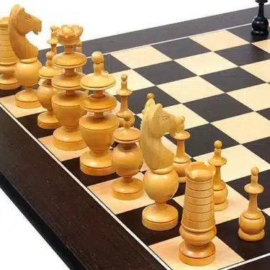 Pièces claires du jeu Palais Français alignées sur l'échiquier en wengé
