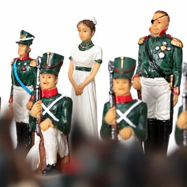 Pièces d'échecs détaillant soldats en uniforme vert et dame en robe blanche