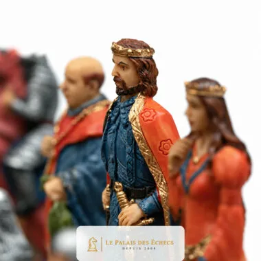 Pièce roi en cape rouge et couronne dorée parmi les figurines médiévales