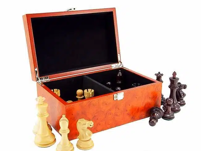 Coffret de rangement avec pièces d'échecs en bois clair et foncé disposées devant