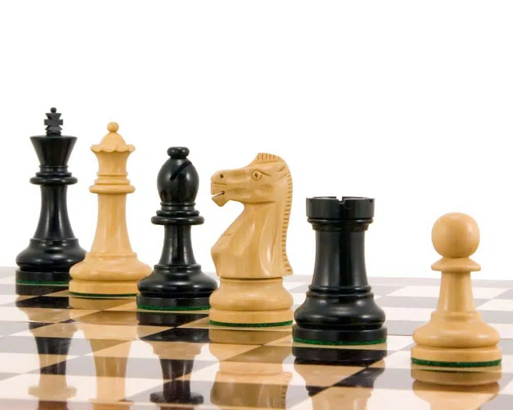 Pièces d'échecs Staunton Supreme III vues en gros plan sur l'échiquier en bois