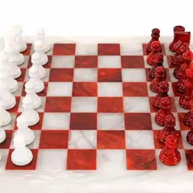 Pièces blanches et rouges en marbre face à face sur l'échiquier