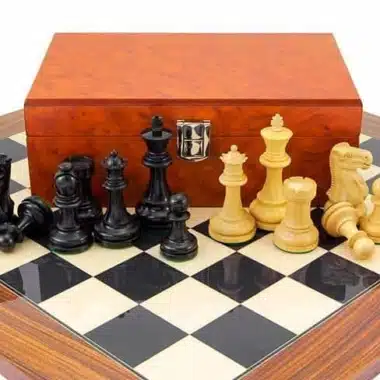 Toutes les pièces du jeu Supreme II disposées devant le coffret fermé en placage de racines