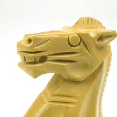 Gros plan sur la tête sculptée d'un cavalier en bois de buis clair