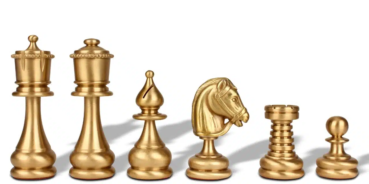 Pièces d'échecs en laiton doré : roi, fou, cavalier et tour alignés