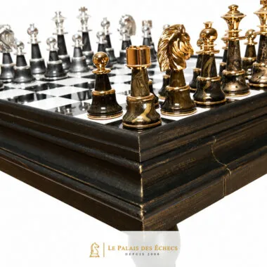 Détail des pièces noires en bois marbré ornées de laiton doré, angle de la table échiquier