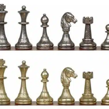 Pièces d'échecs en métal doré et argenté alignées sur l'échiquier