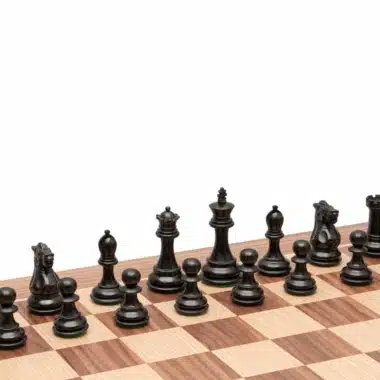 Pièces noires en bois d'ébène du jeu Highclere alignées sur l'échiquier