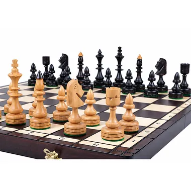 Jeu d'échecs en bois clair et noir disposé sur l'échiquier pliant