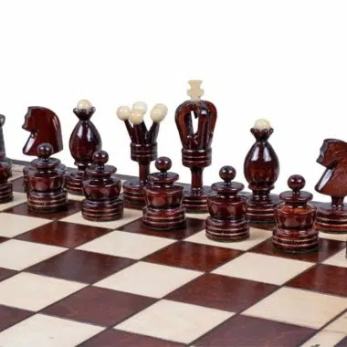 Pièces d'échecs foncées alignées sur l'échiquier, rois, dames et cavaliers visibles