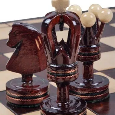 Pièces d'échecs en bois sculpté : cavalier, dame et roi en gros plan