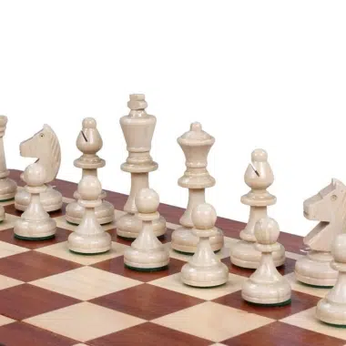 Pièces d'échecs claires en bois naturel alignées sur l'échiquier en gros plan