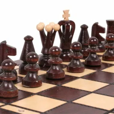 Pièces d'échecs foncées alignées sur l'échiquier vues de face