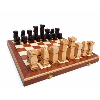 Jeu d'échecs en bois cubique posé sur l'échiquier pliant ouvert