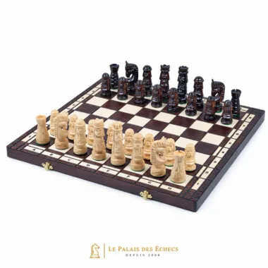Jeu d'échecs sculpté en bois disposé sur un échiquier pliant ouvert