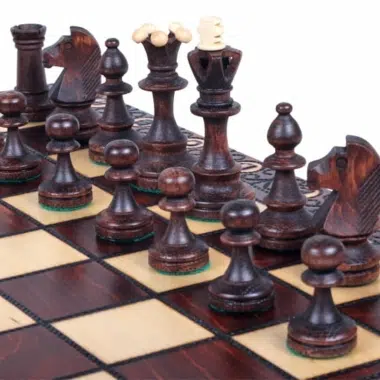 Détail des pièces d'échecs foncées sur l'échiquier en bois