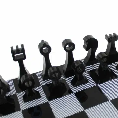 Pièces d'échecs noires en plexiglas, détail des silhouettes sur l'échiquier
