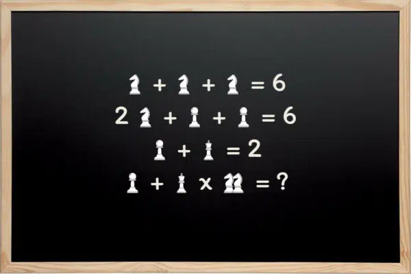 Tableau noir avec énigme mathématique illustrée par des pièces d'échecs