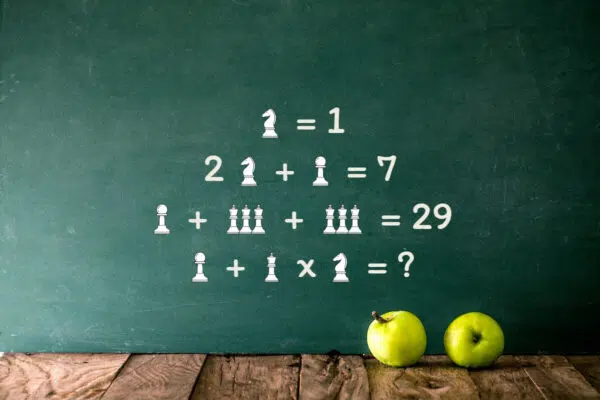 Tableau d'école avec équation mathématique en pièces d'échecs et pommes vertes