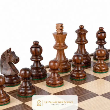 Pièces d'échecs foncées en bois de rose alignées sur l'échiquier