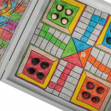 Détail du plateau de Ludo, zones colorées et dés, ambiance familiale - Le Palais Des Echecs