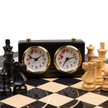Chronomètre de compétition et pièces d'échecs sur un plateau noir