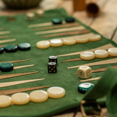 Backgammon en daim vert forêt sur une table en bois, pièces prêtes pour jouer - Le Palais Des Echecs