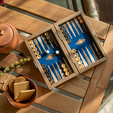 Jeu de backgammon en noyer posé sur une table en bois, ambiance conviviale - Le Palais Des Echecs