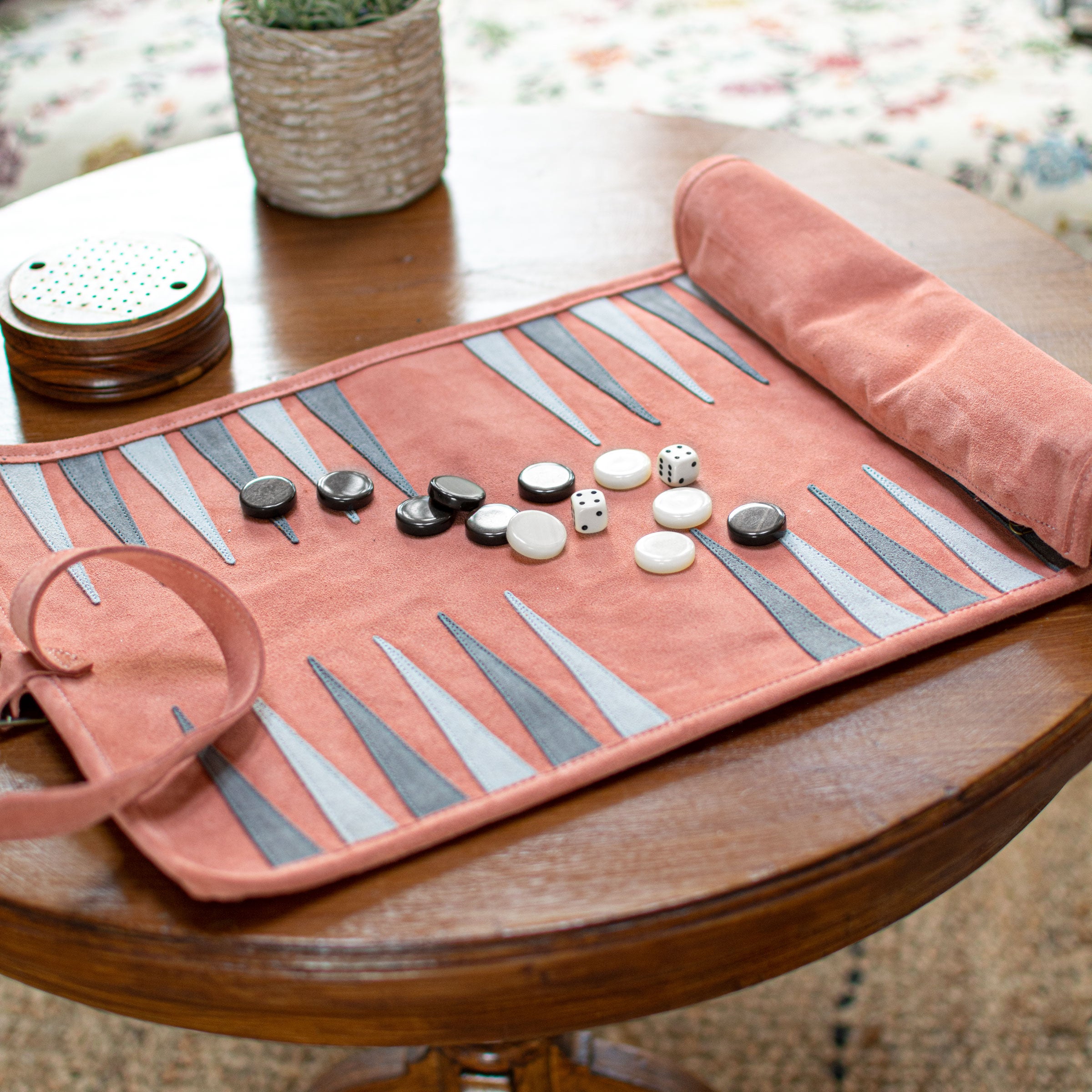 Ensemble de Backgammon en daim saumon sur une table, ambiance conviviale - Le Palais Des Echecs