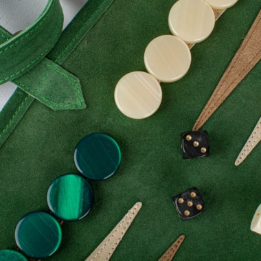 Gros plan sur les pièces du backgammon en daim vert forêt et dés à jouer