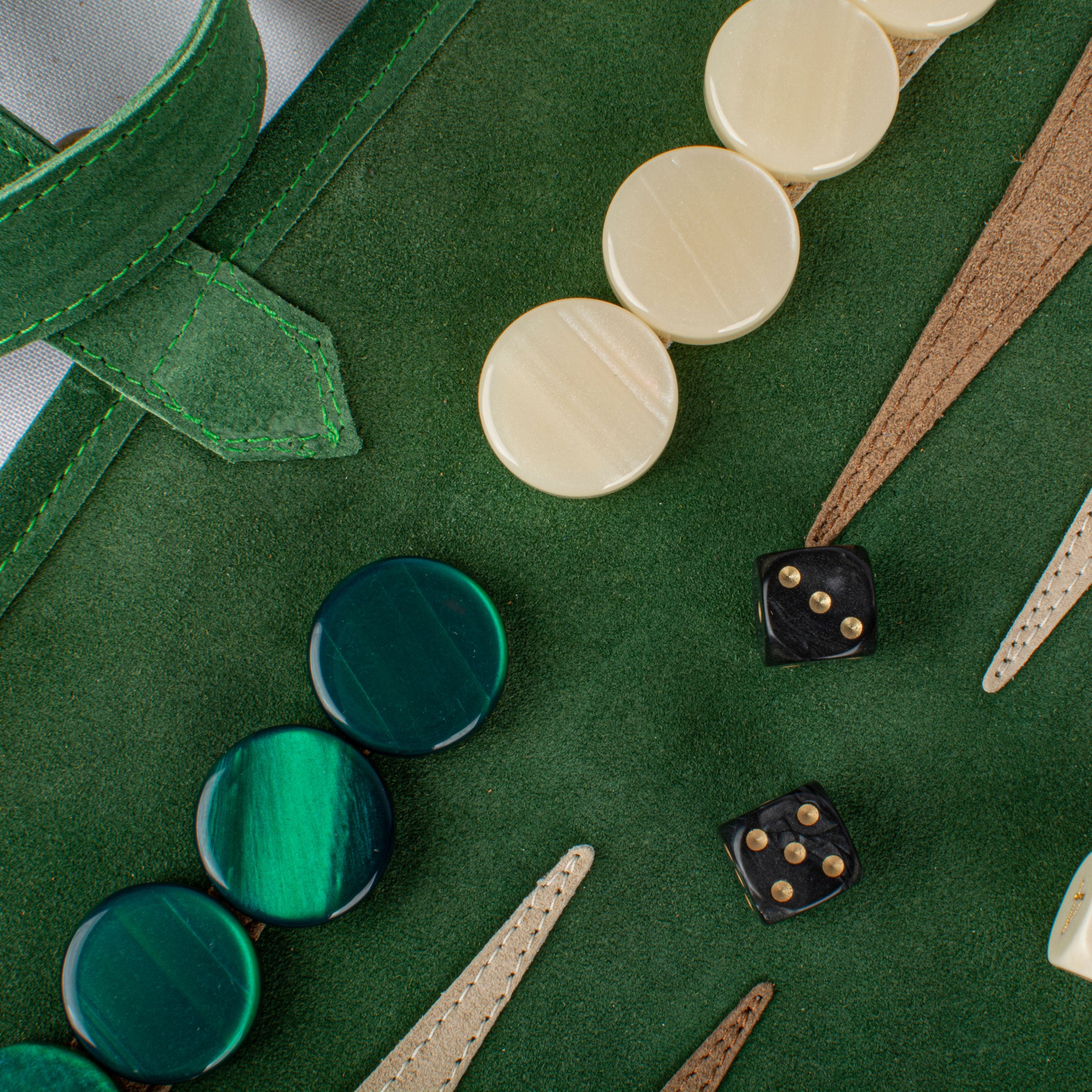 Gros plan sur les pièces du backgammon en daim vert forêt et dés à jouer