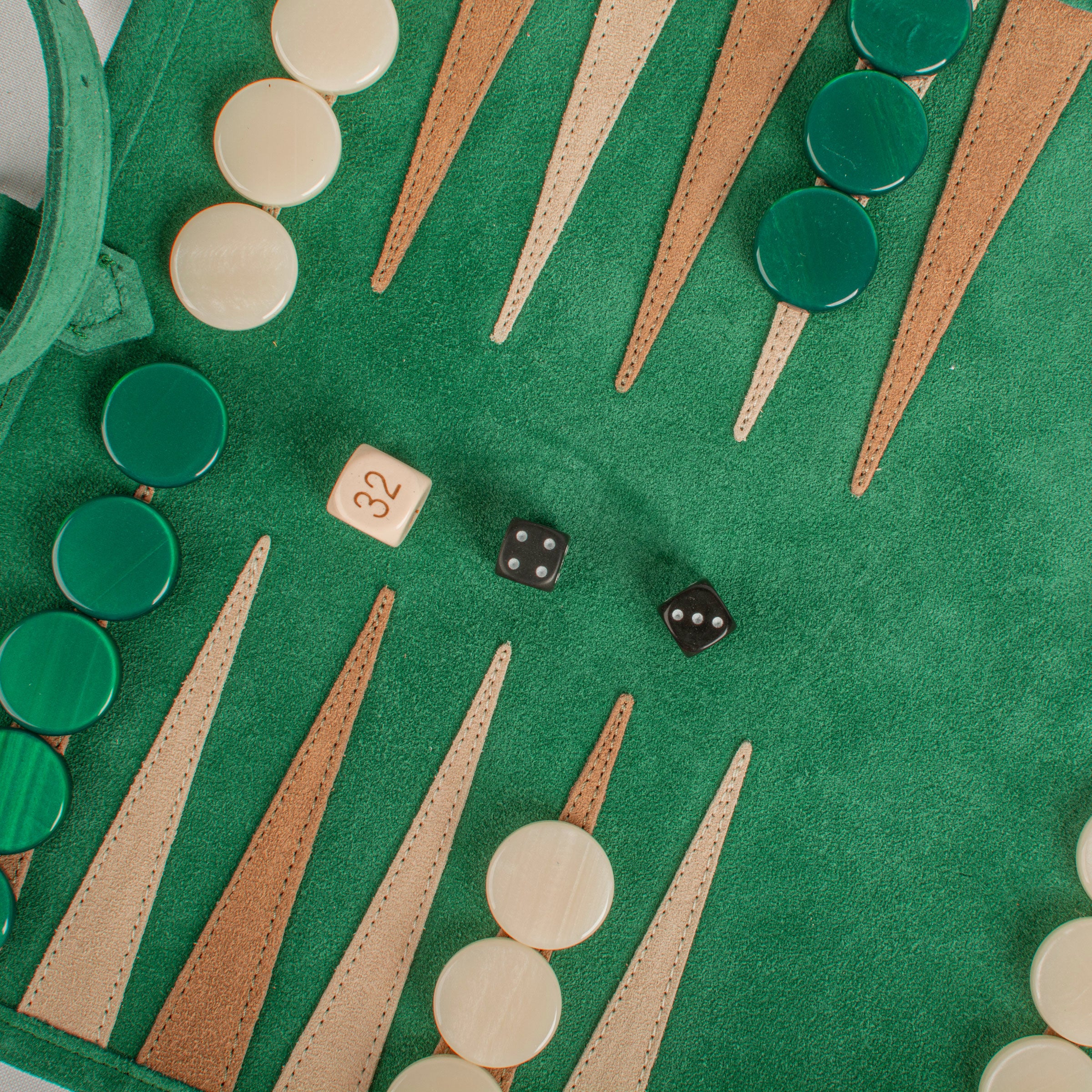 Vue rapprochée des pièces sur le backgammon en daim vert forêt, ambiance conviviale