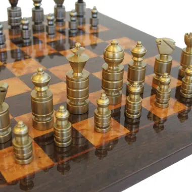 Pièces d'échecs contemporaines dorées en laiton massif alignées sur l'échiquier