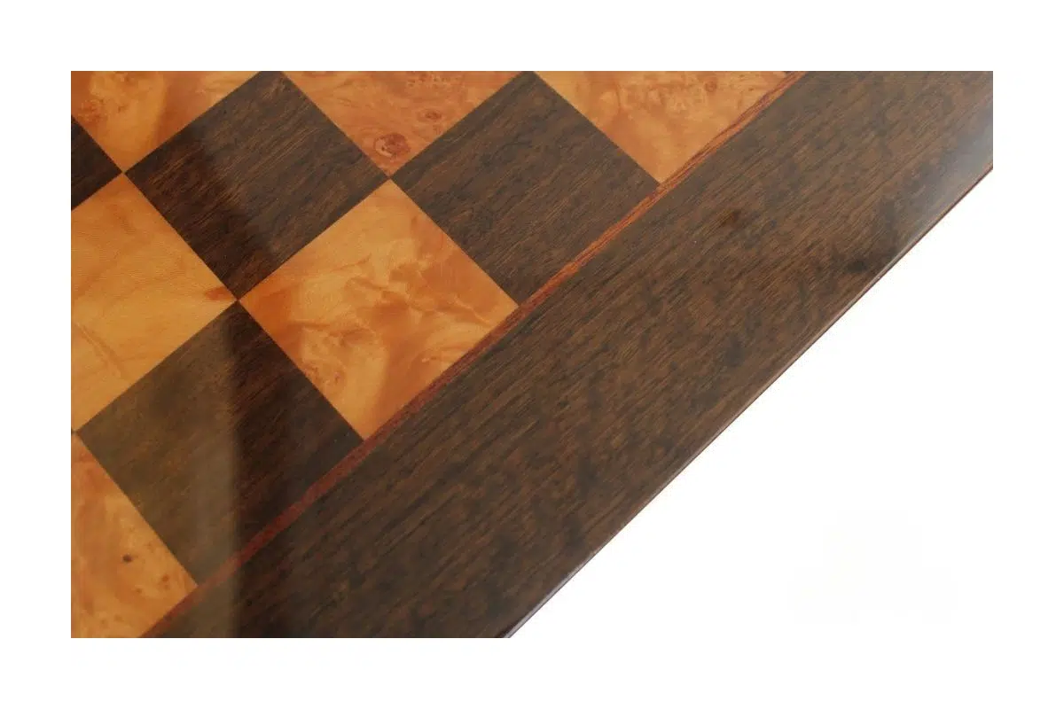Gros plan sur la marqueterie laquée en loupe de bruyère et érable de l'échiquier