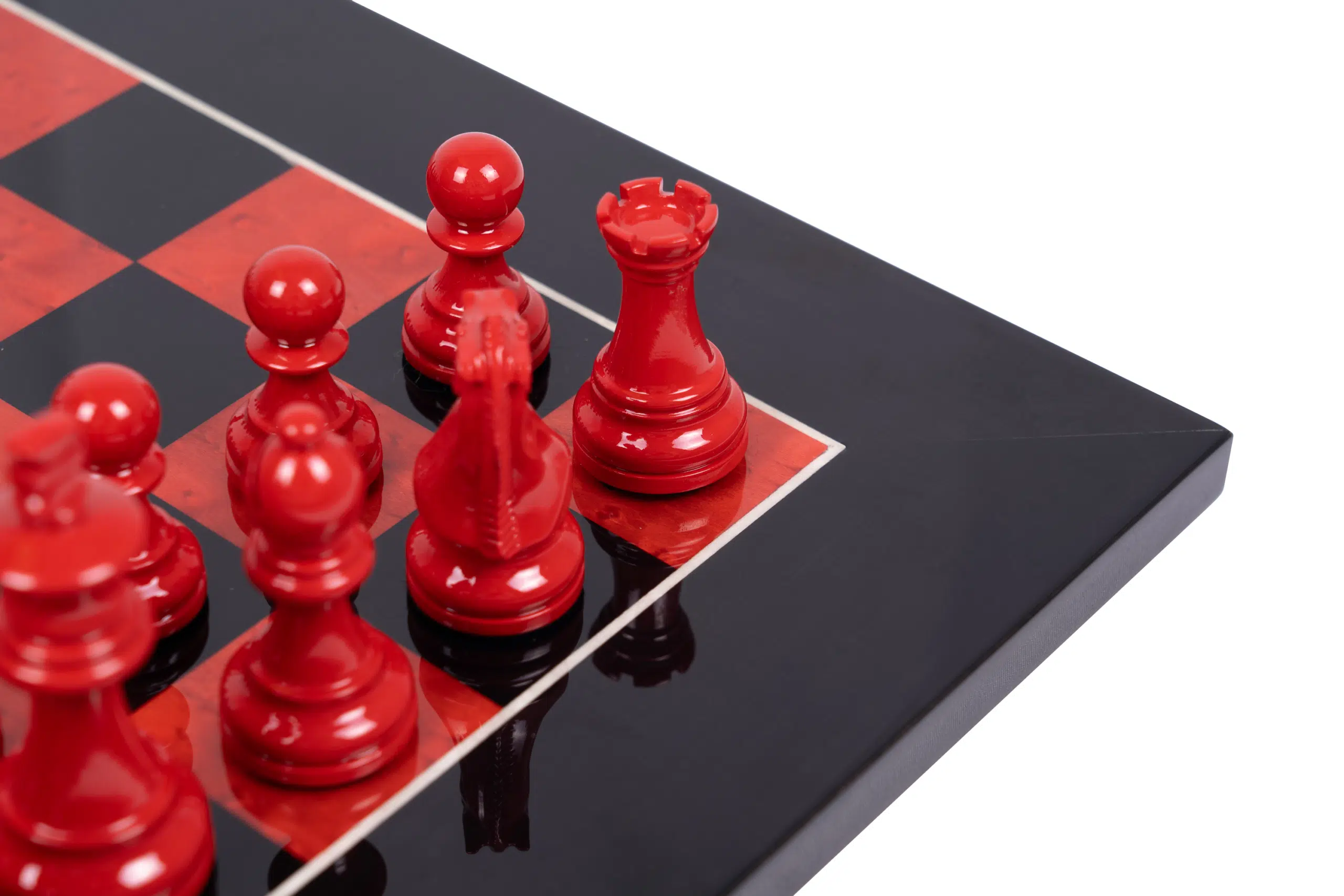 Gros plan sur les pièces d'échecs rouges laquées et la finition miroir de l'échiquier