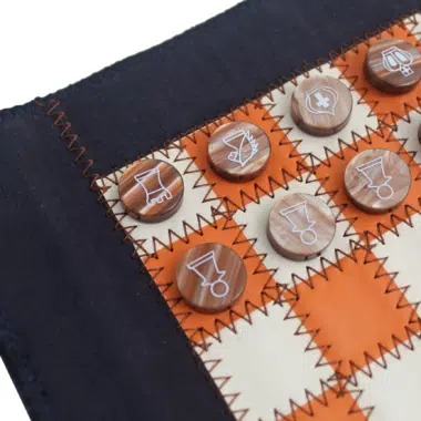Détail des pièces d'échecs marbrées brunes gravées sur échiquier en tissu