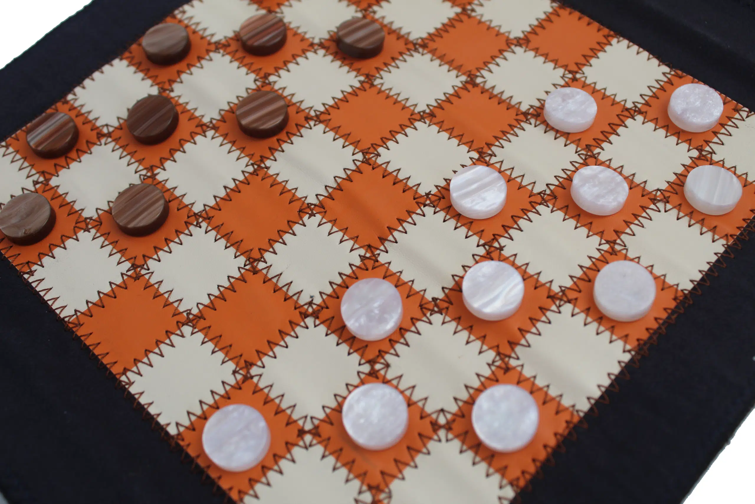 Plateau du jeu de dames sur tapis souple orange et crème avec jetons marbrés