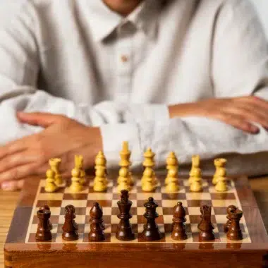 Jeune joueur avec jeu d'échecs en bois sur une table, prêt à commencer une partie - Le Palais Des Echecs